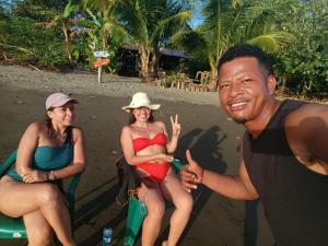 a group of people sitting on a bench on the beach at Cabañas Guaimia in Nuquí