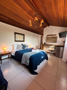 a bedroom with a large bed with a wooden ceiling at Casa Valldemossa in Búzios
