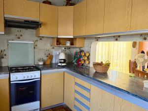 a kitchen with wooden cabinets and a stove top oven at Moradia Vila Real Sto Antonio in Vila Real de Santo António +5 photos