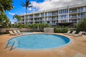 a swimming pool in front of a large building at Puako Beach 309 Oceanview 3BR Condo in Waikoloa