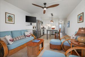 a living room with a blue couch and a table at Puako Beach 309 Oceanview 3BR Condo in Waikoloa