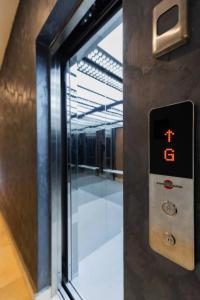 an elevator door with a digital clock on it at Wentworth - SKYSUITES in Accra