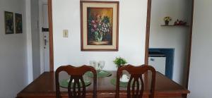 a dining room table with two chairs and a painting at Ita Green in Teresópolis