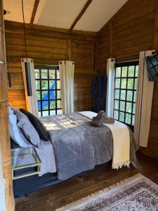 a bedroom with a large bed in a room with windows at Floresta das Evas in Petrópolis +17 photos