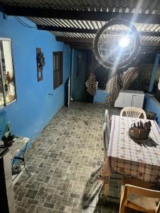 a table and chairs in a room with blue walls at Abrigo e Camping Recanto das Arvores in Itamonte