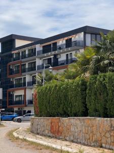 a building with a palm tree in front of it at Grand Lake View Apartment in Ohrid