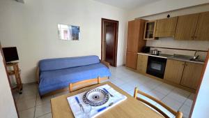 a room with a bed and a table and a kitchen at Marinello house in Oliveri