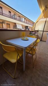 a table and chairs on top of a balcony at Marinello house in Oliveri