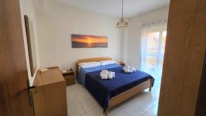a bedroom with a bed with two towels on it at Marinello house in Oliveri