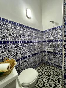 a bathroom with a toilet and blue and white tiles at Riad Le Lieu in Tiznit +46 photos