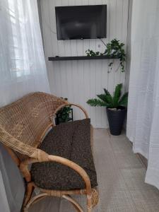 a wicker chair sitting in a room with a television at 2 Pools - Solar - Playa Santa - Apto E in Guanica