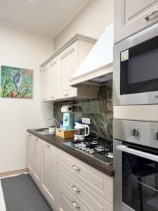 a kitchen with white cabinets and a stove top oven at Catalano Suite Marina - Vista Mare in Palermo