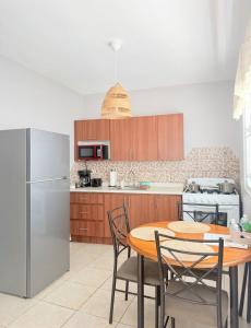 a kitchen with a table and a refrigerator at 2 Pools - Solar - Playa Santa - Apto E in Guanica