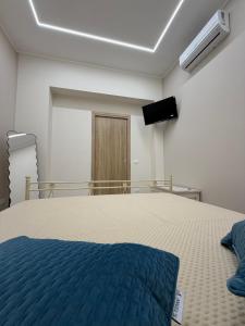 a bedroom with a bed and a tv on the wall at Catalano Suite Marina - Vista Mare in Palermo