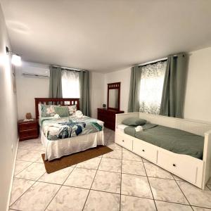 a bedroom with two beds and two windows at Spacious 2BR Apt - Kitchen - Laundry - WiFi in Yauco +4 photos