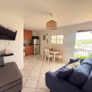 a living room with a blue couch and a table at Spacious 2BR Apt - Kitchen - Laundry - WiFi in Yauco