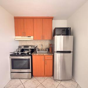 a kitchen with wooden cabinets and a stainless steel refrigerator at Spacious 2BR Apt - Kitchen - Laundry - WiFi in Yauco