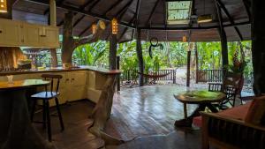 a kitchen with a bar and a table and chairs at Tree House Beachfront Lodge in Puerto Viejo