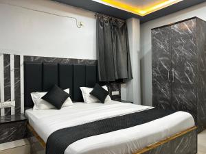 a bedroom with a large bed with a black headboard at Hotel Jay Palace in Saraipāli