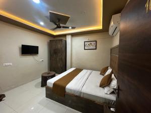 a bedroom with a bed with a ceiling fan at Hotel Jay Palace in Saraipāli