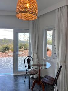 a dining room with a table and chairs and a window at Olymp Spa Boutique Hotel in Monte das Gameleiras