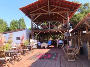 a patio with tables and chairs on a wooden deck at Ponte Pedra Melides -Nature & Ocean- Adults Only in Melides +96 photos