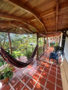 a porch with a hammock on a patio at Casa Solar in Guatapé
