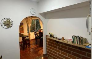 a hallway with a clock on the wall and a table at Casa Solar in Guatapé
