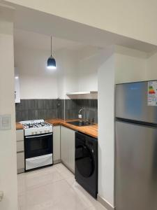a kitchen with a stove and a sink and a refrigerator at Colón 2 in Mar del Plata