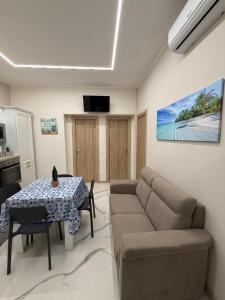 a living room with a couch and a table at Catalano Suite Giada - Vista Mare in Palermo