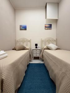 two beds sitting next to each other in a room at Catalano Suite Giada - Vista Mare in Palermo