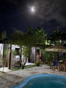 a house with a swimming pool at night at Pousada Caravelas in São Miguel do Gostoso