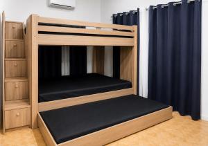 a bunk bed in a room with blue curtains at Nomads Retreat House in Moalboal