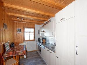 a kitchen with white cabinets and a wooden ceiling at Glashof in Sankt Georgen im Schwarzwald