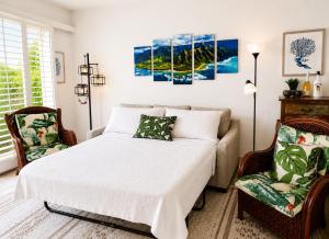 a bedroom with a bed and a chair at Poipu Beach Condo with AC and Pool in Koloa +26 photos