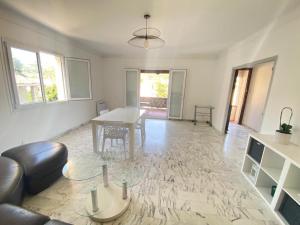 a living room with a table and a couch at Villa Emeraude in Cagnes-sur-Mer
