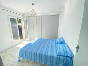 a bedroom with a bed with a blue comforter at Villa Emeraude in Cagnes-sur-Mer