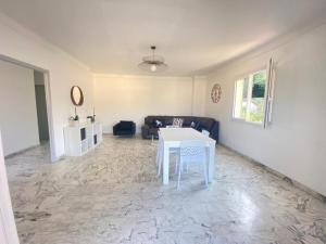 a living room with a white table and a couch at Villa Emeraude in Cagnes-sur-Mer