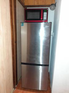 a refrigerator with a microwave on top of it at Walk to Beach - Pool - Billar - Apto D in Guanica