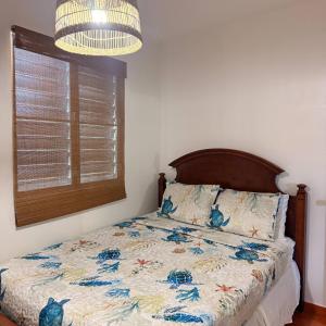 a bedroom with a bed with a comforter and a window at Walk to Beach - Pool - Billar - Apto D in Guanica +67 photos