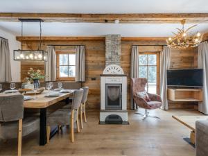 a dining room with a fireplace and a dining table with a stove at Chalet Paul in Katschberghöhe