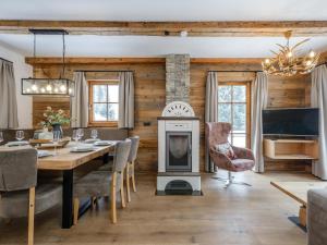 a dining room with a fireplace and a table with chairs at Chalet Cornelia in Gatschberg
