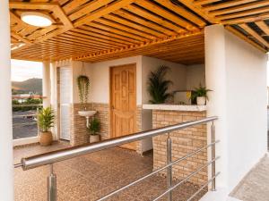 a porch with a wooden door and potted plants at Brisa y Lienzo - Hostal Boutique in Puerto Colombia