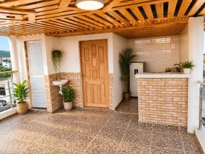 a room with a wooden door and a brick wall at Brisa y Lienzo - Hostal Boutique in Puerto Colombia