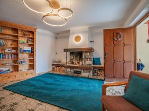 a living room with a fireplace and a blue rug at Das Bergnest Dorfglück in Söll