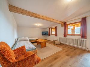 a bedroom with a bed and a chair and a table at Das Bergnest Salvenblick in Söll