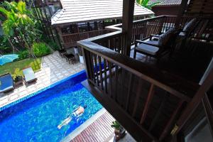une personne se baignant dans une piscine sur un balcon dans l'établissement Banthai Village, à Chiang Mai