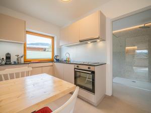 a kitchen with a wooden table and a dining room at Das Bergnest Heimatblick in Söll