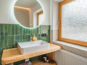 a bathroom with a white sink and a mirror at Das Bergnest Heimatblick in Söll +18 photos