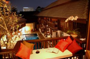 a balcony with a table with pillows and a pool at Banthai Village in Chiang Mai